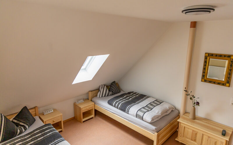 Gästezimmer der Ferienwohnung Dorfzauber mit zwei Einzelbetten und Fenstern Gästezimmer der Ferienwohnung Dorfzauber mit zwei Einzelbetten und Fenstern