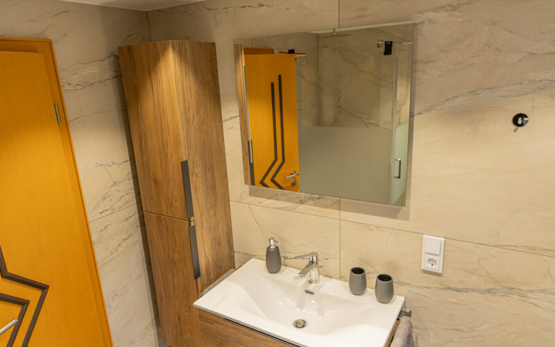 Helles Badezimmer mit Waschbecken und Dusche Helles Badezimmer mit Waschbecken und Dusche