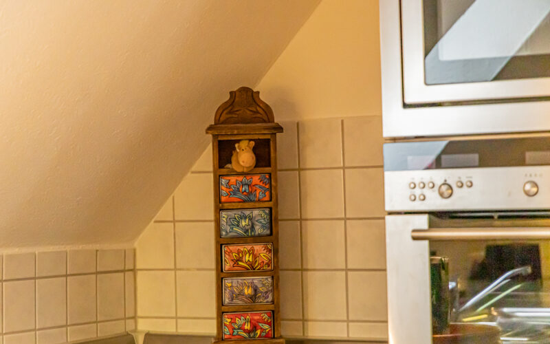 Küchenbereich unter der Dachschräge mit Gewürzregal Dekoration mit Eule und Lampe in der Küche